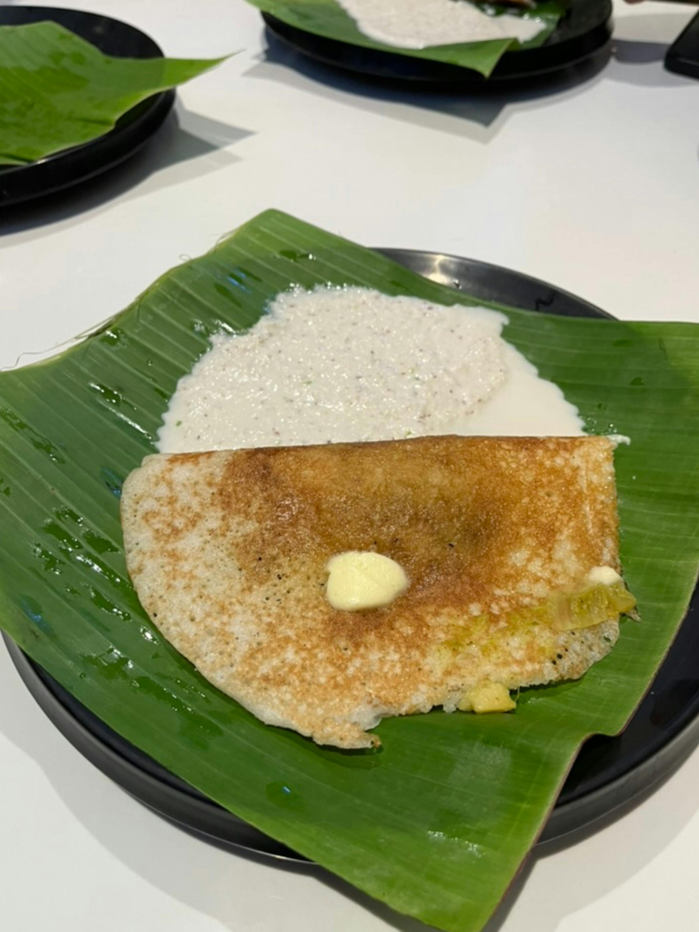 Traditional South Indian masala dosa on a banana leaf, freshly delivered by MezZingo